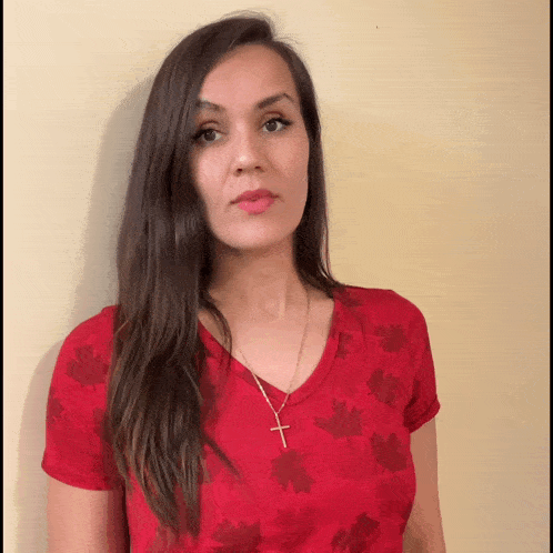 a woman is wearing a red shirt with maple leaves on it