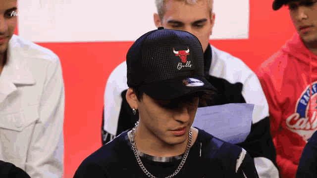 a man wearing a chicago bulls hat sits in a crowd