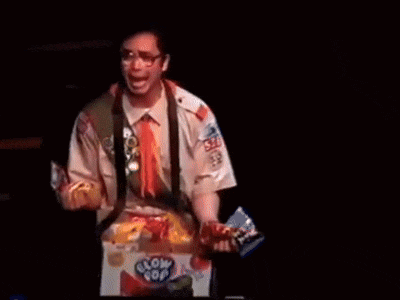 a man in a boy scout uniform holds a box of glow pop