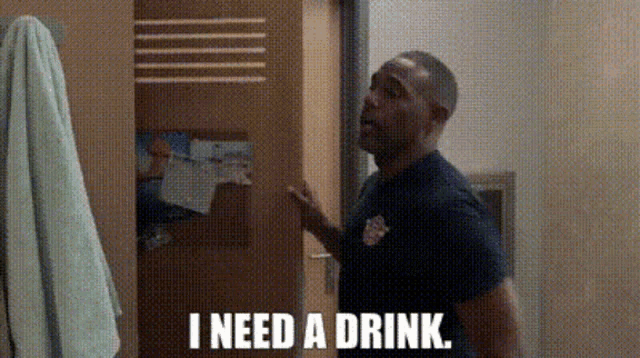 a man standing in front of a door with the words i need a drink