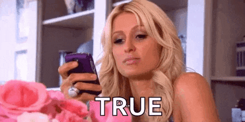 a woman is taking a picture of herself with a cell phone and says `` true '' .