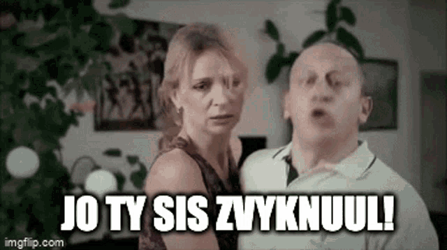a man and a woman are standing next to each other in a living room and the woman is yelling at the man .
