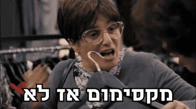 a woman with glasses is holding a hanger in her mouth and the words in hebrew are visible above her
