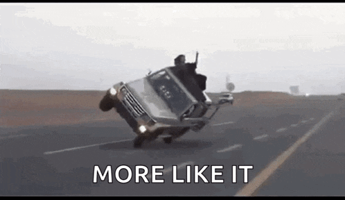 a man is riding on top of a car on a road .