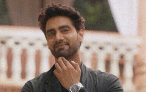 a man with a beard and a watch on his wrist is smiling