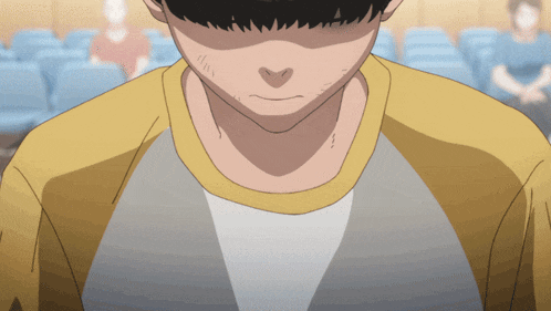a close up of a man 's face with a yellow shirt on