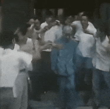 a man in a blue jacket is surrounded by people