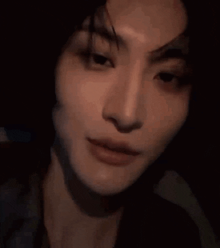 a close up of a woman 's face in a dark room .