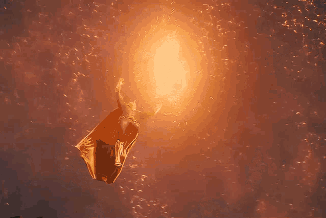a person is flying through the air with a large explosion behind them