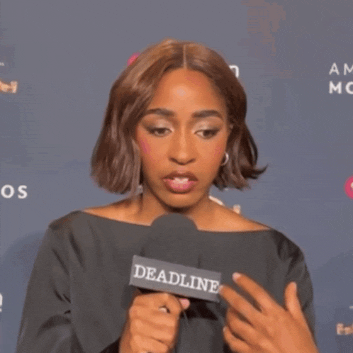 a woman holding a microphone that says deadline