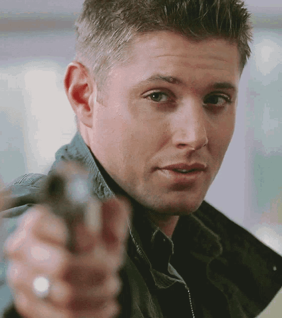 a man with a ring on his finger is holding a gun