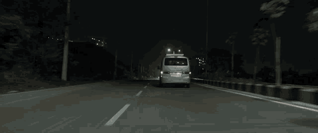 a silver van is driving down a road at night with a license plate that says ' a ' on it