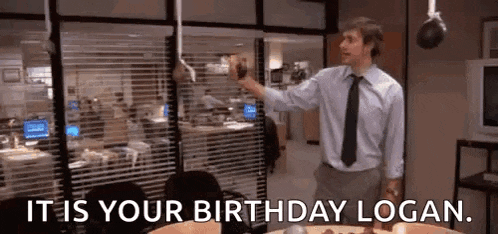 a man in a suit and tie is standing in front of a cake in an office .