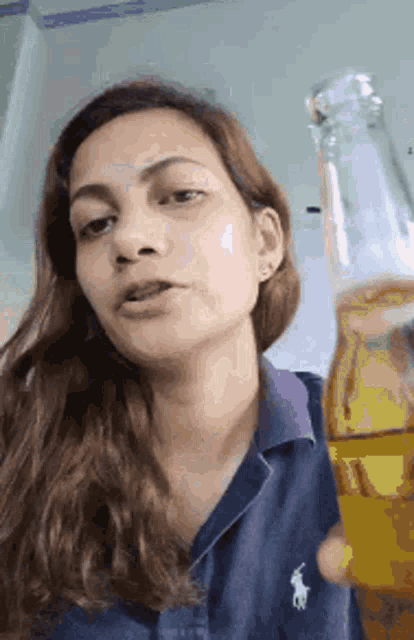 a woman is holding a bottle of beer in her hand