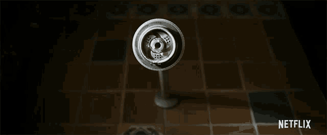 a shower head is spraying water in a dark bathroom .