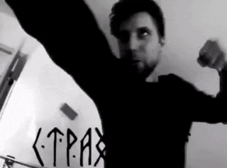 a man is flexing his muscles in a black and white photo with the word tpax written on the wall .