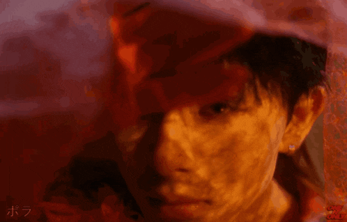 a close up of a man 's face with a red background