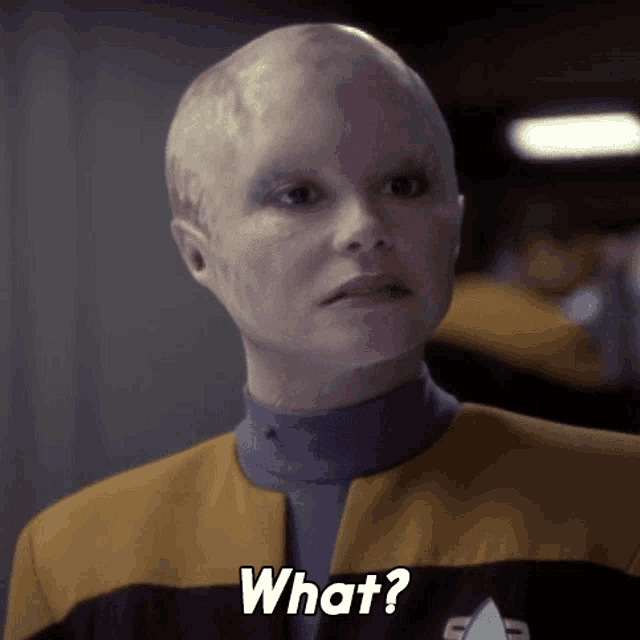 a woman with a shaved head says " what "