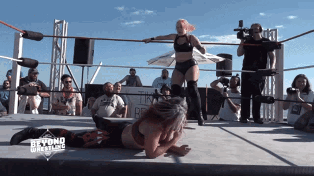 two women are wrestling in a ring with beyond wrestling written on the bottom