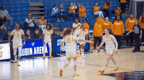 a group of women playing basketball in front of a sign that says ' lubin arena '