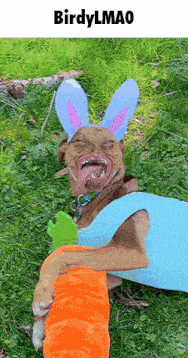 a dog is wearing bunny ears and holding a carrot in the grass