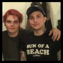 two men are posing for a picture and one has a sun of a beach shirt on