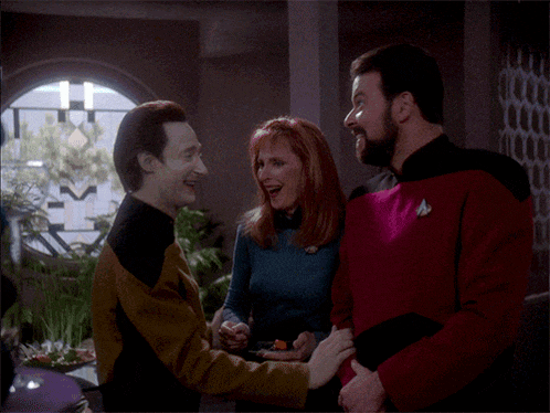 a man and a woman are laughing in a room