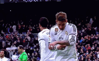 two soccer players are hugging each other and one has fly emirates on his shirt