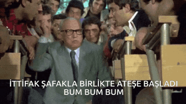 a man in a suit and tie is surrounded by a crowd of people with the words bum bum bum written on the bottom