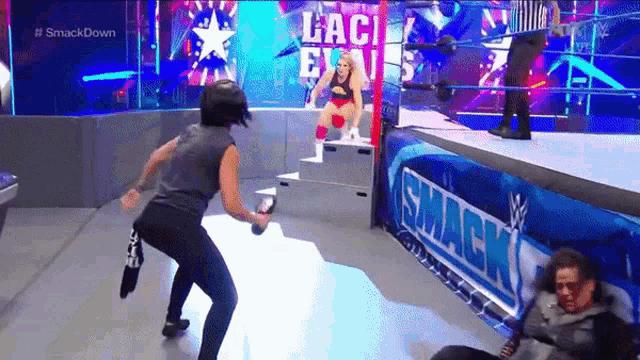 a woman is holding a microphone in a wrestling ring .