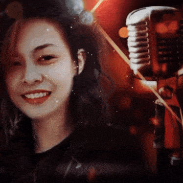 a woman is smiling in front of a microphone with a red background