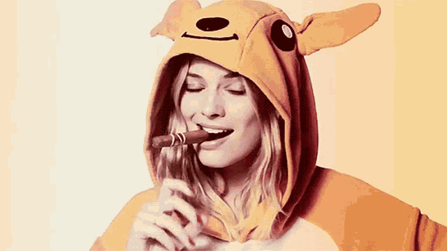 a woman is wearing a kangaroo costume and eating a chocolate bar .