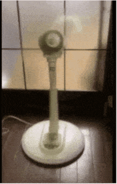 a white fan is sitting on a wooden floor