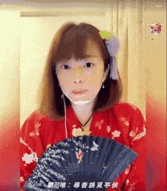 a woman in a red kimono is holding a fan with chinese writing on it