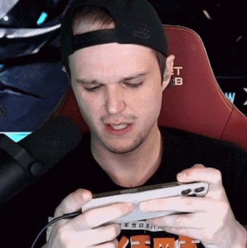 a man playing a game on a phone with the letter t on the back
