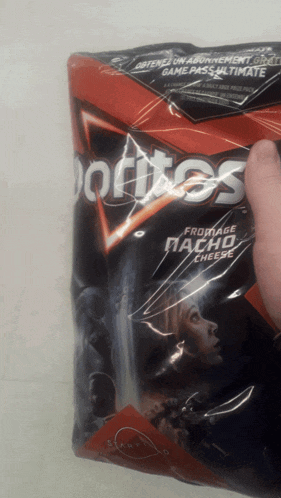 a person is holding a bag of doritos cheese