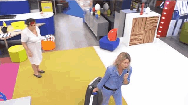 a woman carrying a suitcase in a room with a sign that says ' italy '