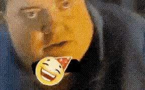 a man is wearing a party hat and holding a smiley face pin in his mouth .