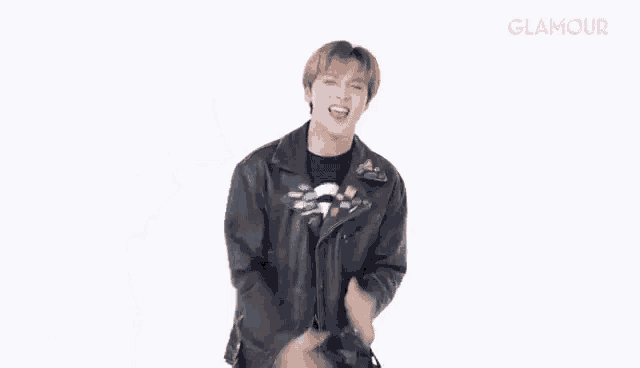 a young man in a leather jacket is dancing .