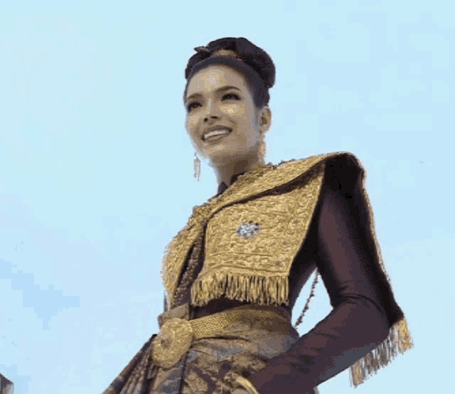 a woman in a traditional costume is smiling and looking up at the sky .