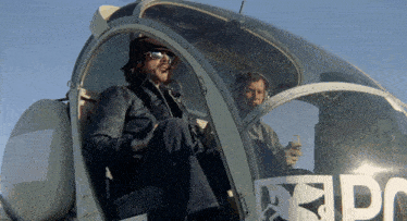 two men are sitting in a helicopter with the word epd on the front