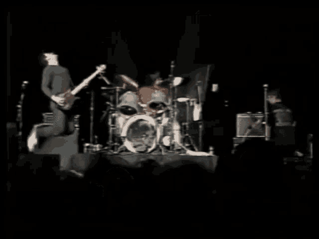 a man playing a guitar and a man playing drums on a stage