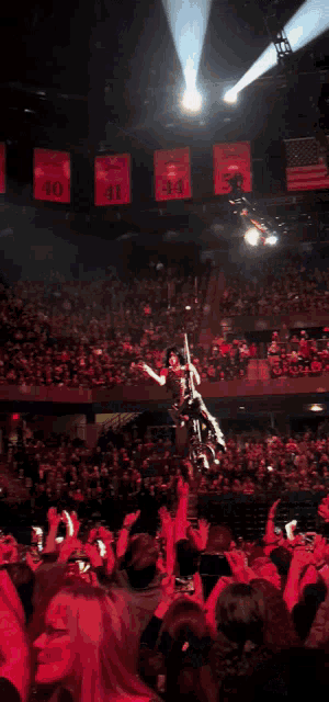a man is hanging upside down in the air with a microphone in his hand