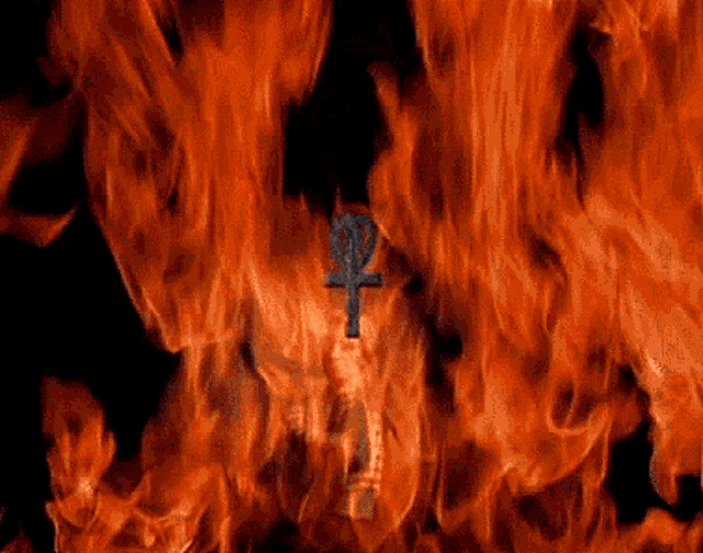 a skull is surrounded by flames and a cross