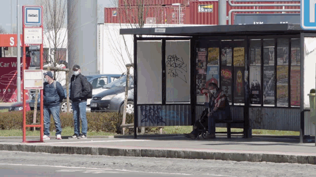 people waiting at a bus stop with a sign that says ' s ' on it