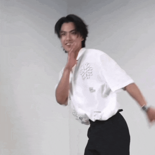 a man wearing a white shirt and black pants is dancing .
