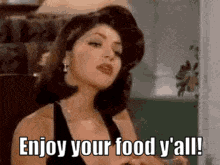 a woman in a black tank top is saying enjoy your food y 'all .