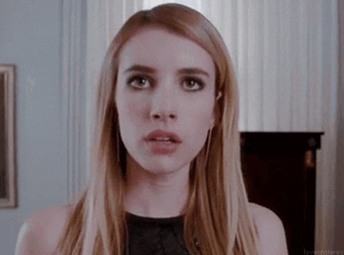 a woman with long blonde hair is making a funny face in a room .