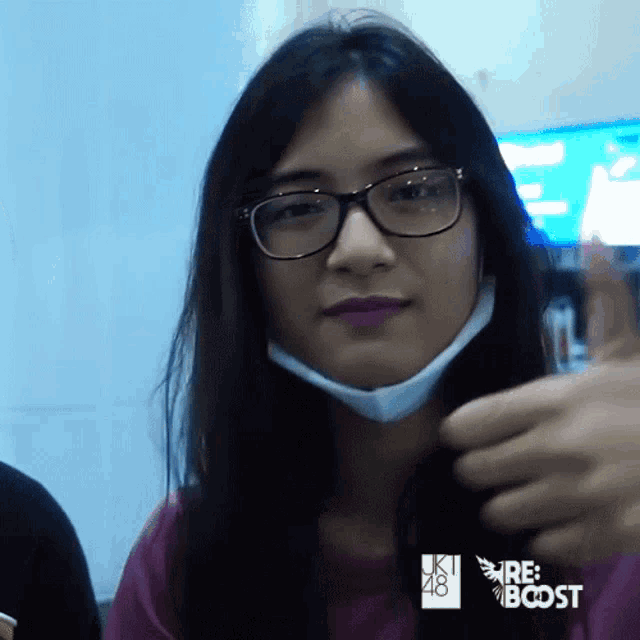 a woman wearing glasses and a mask is giving the thumbs up