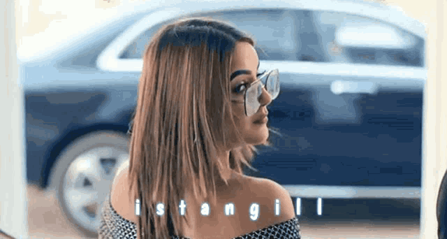 a woman wearing glasses is standing in front of a car with the word istanbul on the bottom